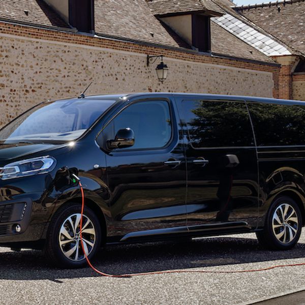 Citroen e-space tourer, parked and charging in courtyard. Front 3/4, black car